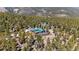 Stunning aerial view of the home and property, surrounded by lush forest, solar panels, and additional structures at 14800 Gold Hill Rd, Boulder, CO 80302
