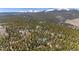 Scenic aerial view of the mountain property surrounded by lush trees and snow-capped peaks in the background at 14800 Gold Hill Rd, Boulder, CO 80302