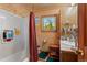 Bathroom featuring a shower/tub combo, wood wall, and sink with vanity offering both style and functionality at 14800 Gold Hill Rd, Boulder, CO 80302