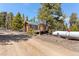 Outdoor view of home with wood detail, surrounded by trees and gravel at 14800 Gold Hill Rd, Boulder, CO 80302