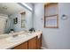 Bathroom with double sinks, mirror, and window at 4426 Windmill Dr, Brighton, CO 80601