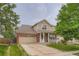 Charming two-story home featuring a brick facade, inviting porch, and well-manicured lawn at 4426 Windmill Dr, Brighton, CO 80601