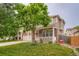 Inviting home exterior with brick accents, a cozy front porch, and a lush green lawn at 4426 Windmill Dr, Brighton, CO 80601