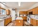 Bright kitchen with wooden cabinets, island, stainless steel refrigerator, and lots of counter space at 4426 Windmill Dr, Brighton, CO 80601
