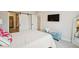Bedroom with TV, white comforter, large bright window, and access to the ensuite bathroom at 10062 W Victoria Pl # 205, Littleton, CO 80127