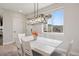 Bright dining area featuring a white wooden table and a modern chandelier at 10062 W Victoria Pl # 205, Littleton, CO 80127