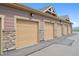 Row of garages with stone accents and tan doors, providing secure parking for residents at 10062 W Victoria Pl # 205, Littleton, CO 80127