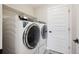 Bright laundry room with new white washer and dryer, plus shelving for convenient storage solutions at 10062 W Victoria Pl # 205, Littleton, CO 80127