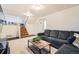 This finished basement is inviting with stairs leading to a comfortable living space with a large dark grey sofa at 2723 E 96Th Way, Thornton, CO 80229