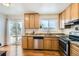 Bright kitchen with stainless steel appliances, wood cabinetry, and sliding door at 2723 E 96Th Way, Thornton, CO 80229