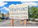 Community sign that reads, 'Viewpoint Condominiums 10211 Ura Lane', with blue skies and landscaping in the background at 10211 Ura Ln # 3-104, Thornton, CO 80260
