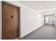 Well-lit hallway with gray carpet leading to unit 104 at 10211 Ura Ln # 3-104, Thornton, CO 80260