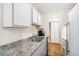 Close up of the kitchen, displaying granite countertops, stainless steel sink, and a dishwasher at 10211 Ura Ln # 3-104, Thornton, CO 80260