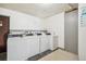Shared laundry room featuring four rows of white washing machines and dryers for residents' convenience at 10211 Ura Ln # 3-104, Thornton, CO 80260
