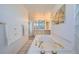 Bright bathroom featuring a whirlpool soaking tub with gold fixtures and an extended vanity counter at 7672 E Arizona Dr, Denver, CO 80231