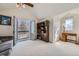 Bright bedroom with a sliding glass door to a balcony, built-in bookshelf, and wooden desk at 7672 E Arizona Dr, Denver, CO 80231