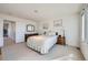 Well-lit bedroom with plush carpeting, white walls, soft bedding, and an adjacent doorway at 7672 E Arizona Dr, Denver, CO 80231