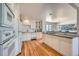 Bright kitchen featuring white cabinets, modern appliances, and hardwood floors at 7672 E Arizona Dr, Denver, CO 80231