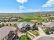 Scenic aerial view of the home and neighborhood with green spaces, a lake, and mountain views in the distance at 9510 Orion Way, Arvada, CO 80007