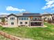 Beautiful backyard with a stone patio and a deck, complemented by lush green grass and solar panels at 9510 Orion Way, Arvada, CO 80007
