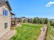 Expansive backyard featuring a well-manicured lawn and inviting stone patio area for outdoor entertainment at 9510 Orion Way, Arvada, CO 80007