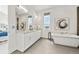 Bright bathroom featuring a double vanity, modern soaking tub and eye-catching art at 9510 Orion Way, Arvada, CO 80007