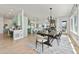 Open-concept dining area featuring a sleek table, modern chandelier, and seamless flow to kitchen and living space at 9510 Orion Way, Arvada, CO 80007