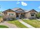 Charming single-story home with stone accents, well-kept lawn, and beautifully landscaped front yard at 9510 Orion Way, Arvada, CO 80007