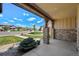 Covered front porch view featuring stone columns, well-manicured landscaping and neighborhood street at 9510 Orion Way, Arvada, CO 80007