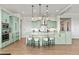 Bright kitchen features a large center island with pendant lighting, light green cabinets, and stainless steel appliances at 9510 Orion Way, Arvada, CO 80007