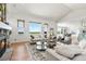Open concept living room with a stone fireplace, hardwood floors, large windows, and neutral decor at 9510 Orion Way, Arvada, CO 80007