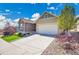 Well-kept home featuring desert landscaping, a paved driveway, and a two-car garage at 12636 Sandstone Dr, Broomfield, CO 80021