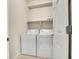 Neat laundry room includes a washer, dryer, and built-in shelf for laundry products at 12636 Sandstone Dr, Broomfield, CO 80021