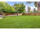 Expansive backyard with a well-kept lawn, wooden fence, and a stone fire pit, providing a serene outdoor retreat at 2680 S Garfield Cir, Denver, CO 80210