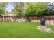 A spacious backyard featuring a swing set, stone fire pit, and ample green space, perfect for relaxation and outdoor activities at 2680 S Garfield Cir, Denver, CO 80210