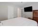 Bright bedroom features a large bed, TV, and ample closet space for storage at 2680 S Garfield Cir, Denver, CO 80210