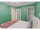 Cozy bedroom with green walls, featuring a bed and a closet at 2680 S Garfield Cir, Denver, CO 80210