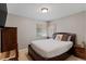 Cozy bedroom with a large bed, wood furniture, and natural light from the window at 2680 S Garfield Cir, Denver, CO 80210