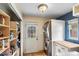 Well-organized laundry room with stacked washer and dryer and storage shelves at 2680 S Garfield Cir, Denver, CO 80210
