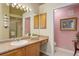 Bright bathroom featuring well-lit vanity, large mirror, and adjoining powder room for convenience at 18324 E Bethany Pl, Aurora, CO 80013