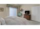 Bedroom with bright natural light, floral valance, and television for relaxation and entertainment at 18324 E Bethany Pl, Aurora, CO 80013