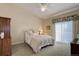 Bright bedroom with light carpet, ceiling fan, and sliding door to balcony with floral valance at 18324 E Bethany Pl, Aurora, CO 80013