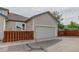 Exterior of a home with a two-car garage, a brown fence, and well-kept landscaping at 18324 E Bethany Pl, Aurora, CO 80013