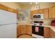 Charming kitchen with a pass-through, oak cabinets, and modern microwave at 18324 E Bethany Pl, Aurora, CO 80013