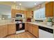 Bright kitchen with oak cabinets, updated appliances, and hardwood floors at 18324 E Bethany Pl, Aurora, CO 80013