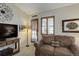 Living room featuring door to the yard, couch, TV, and natural light at 18324 E Bethany Pl, Aurora, CO 80013