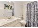 Well-lit bathroom features a marble countertop vanity, decorative mirror, and a shower with patterned curtain at 8613 Santa Fe Dr, Thornton, CO 80260