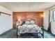 Bedroom showcasing a brick accent wall, iron bed frame, and soft blue carpet at 8613 Santa Fe Dr, Thornton, CO 80260