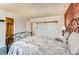 Bedroom showcasing a brick accent wall, iron bed frame, and soft blue carpet at 8613 Santa Fe Dr, Thornton, CO 80260