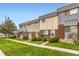 Townhouse exterior features neutral siding and brick accents with manicured lawn and walkway at 8613 Santa Fe Dr, Thornton, CO 80260